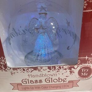 Hand blown glass globe lights up with color, changing LEDs, Angel holding star